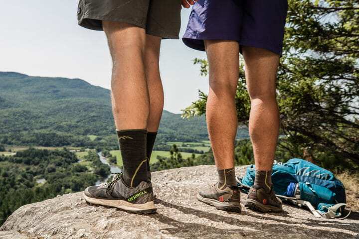 Dos caminantes con montaña verde al fondo