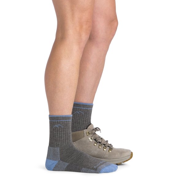 Dos piernas de una modelo con calcetines grises y azules en las dos piernas y en una además una bota gris.