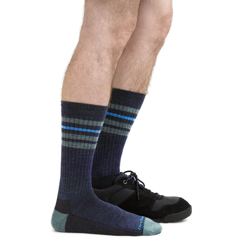 a person is holding a pair of black shoes