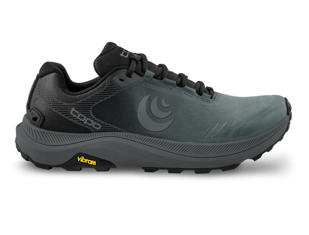 Zapatilla Topo Athletic MT-5 M'S en negro y carbón con suela Vibram para versatilidad en senderos y caminos.