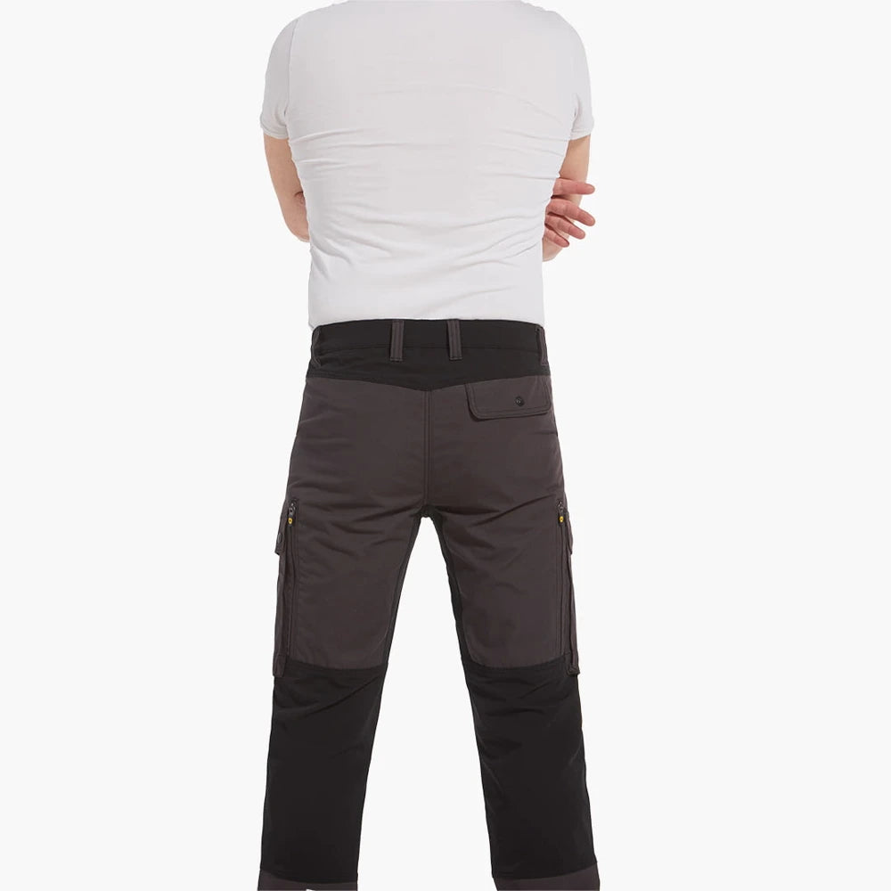 Modelo de espaldas con camiseta blanca con pantalón Rovince Flexline con cinturilla negra y rodillas el resto en gris. 